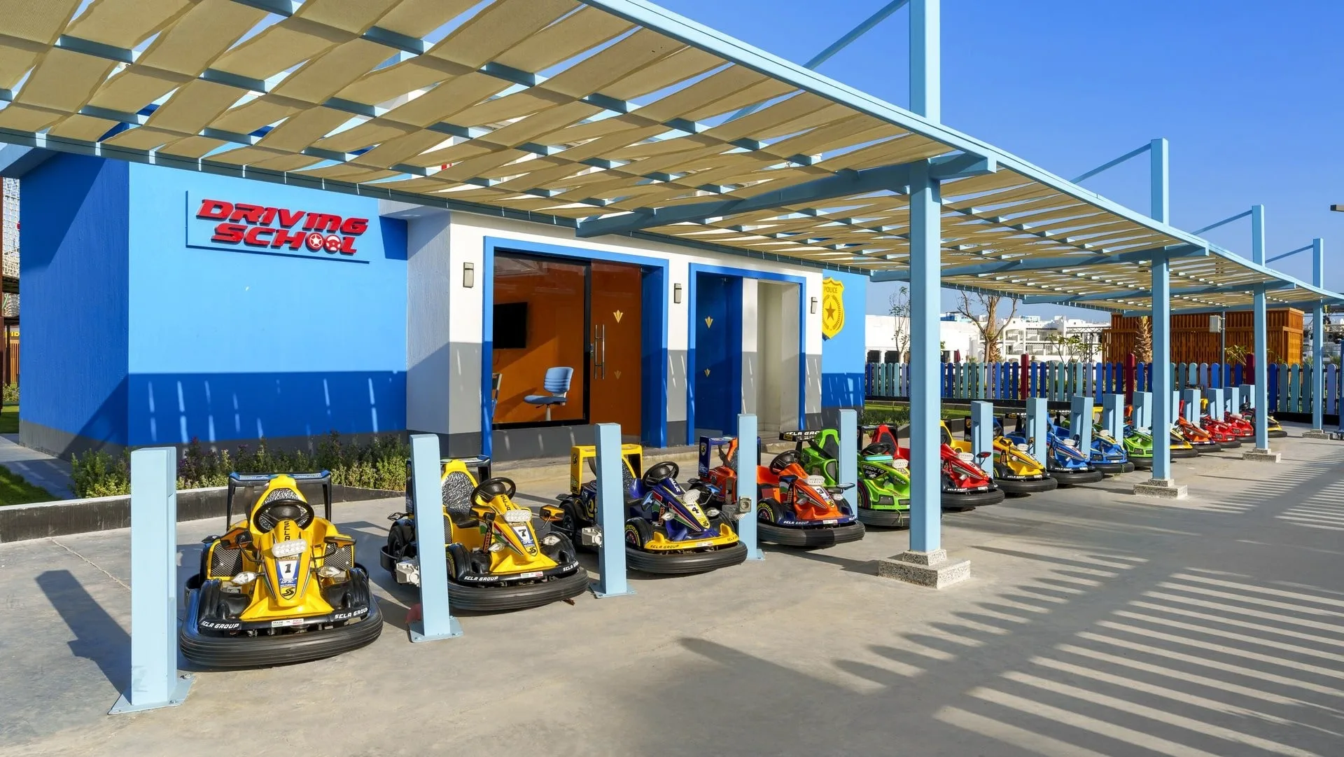 Scuola guida per bambini con go-kart colorati sotto una tettoia