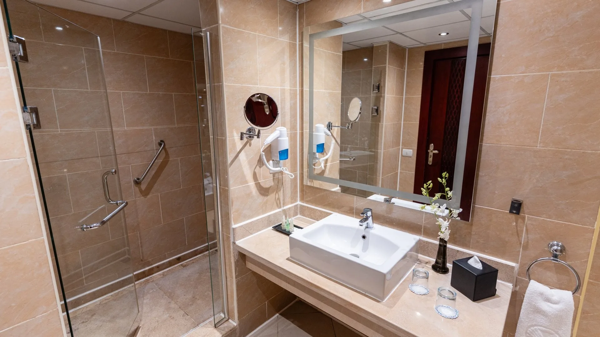 Bagno moderno con doccia in vetro, lavabo e specchio illuminato
