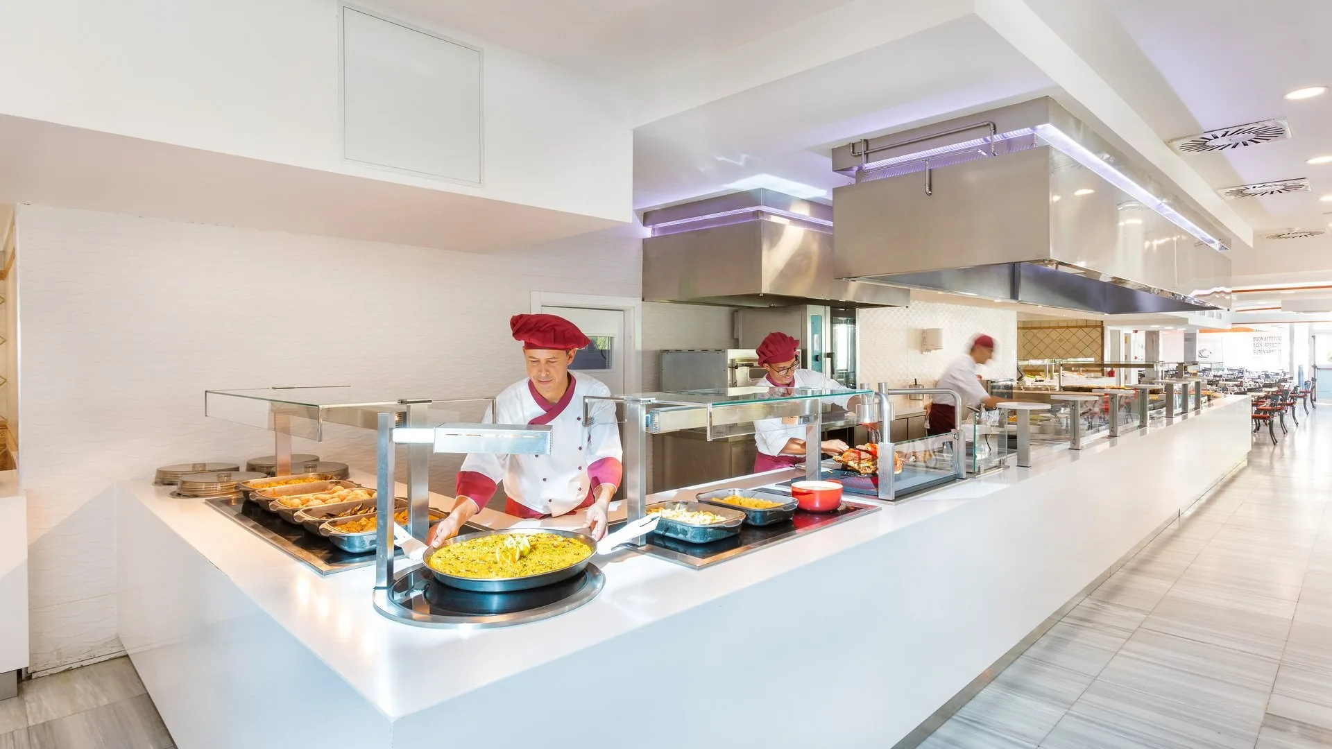 Buffet del ristorante con chef che serve paella e piatti caldi esposti