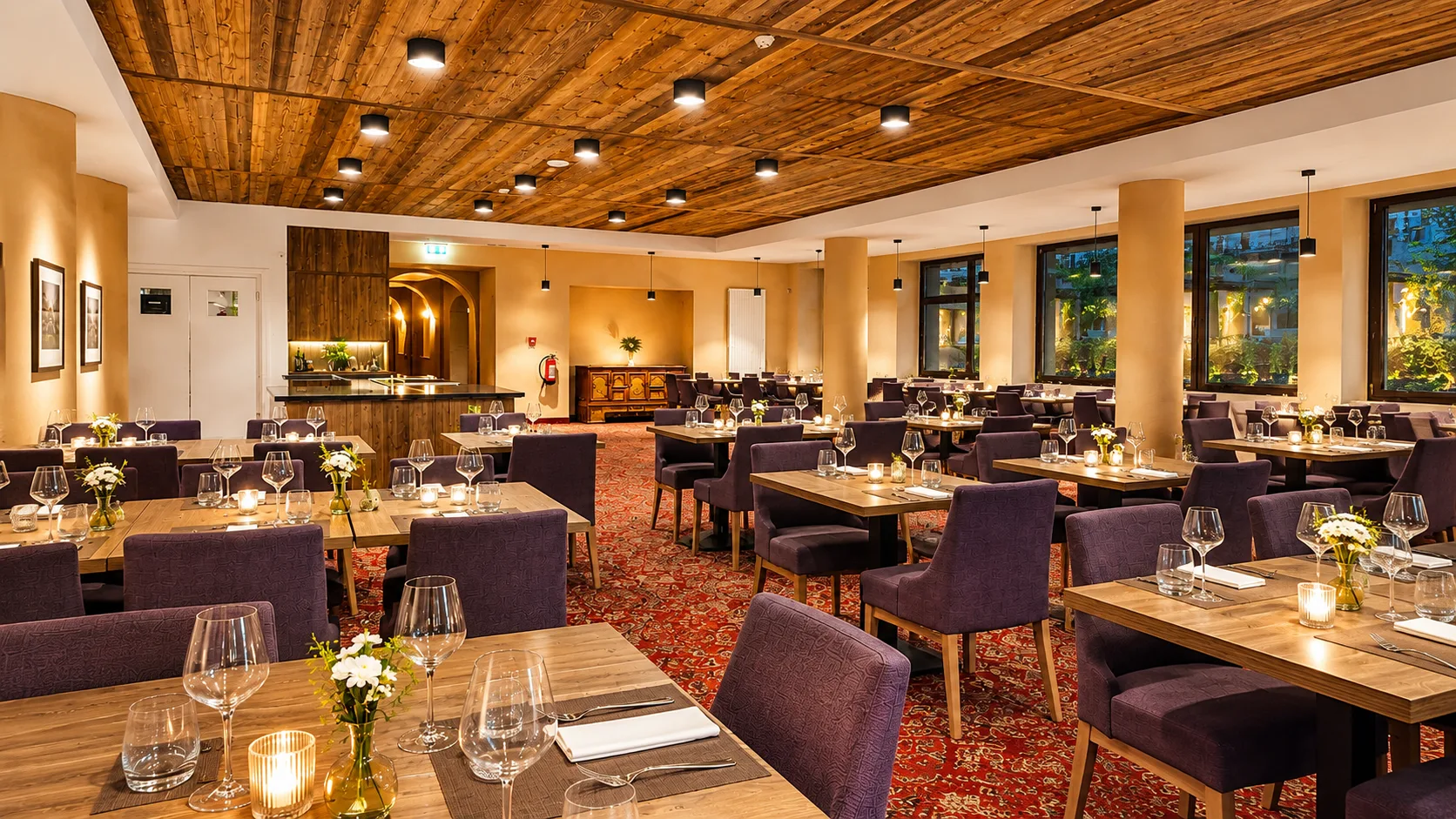 Sala ristorante elegante con tavoli apparecchiati, soffitto in legno e tappeto rosso
