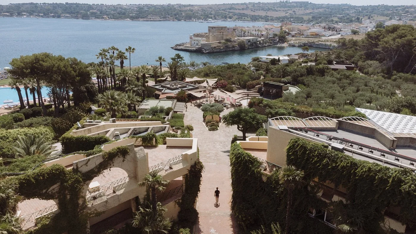 Vista aerea del resort con giardini terrazzati e mare sullo sfondo
