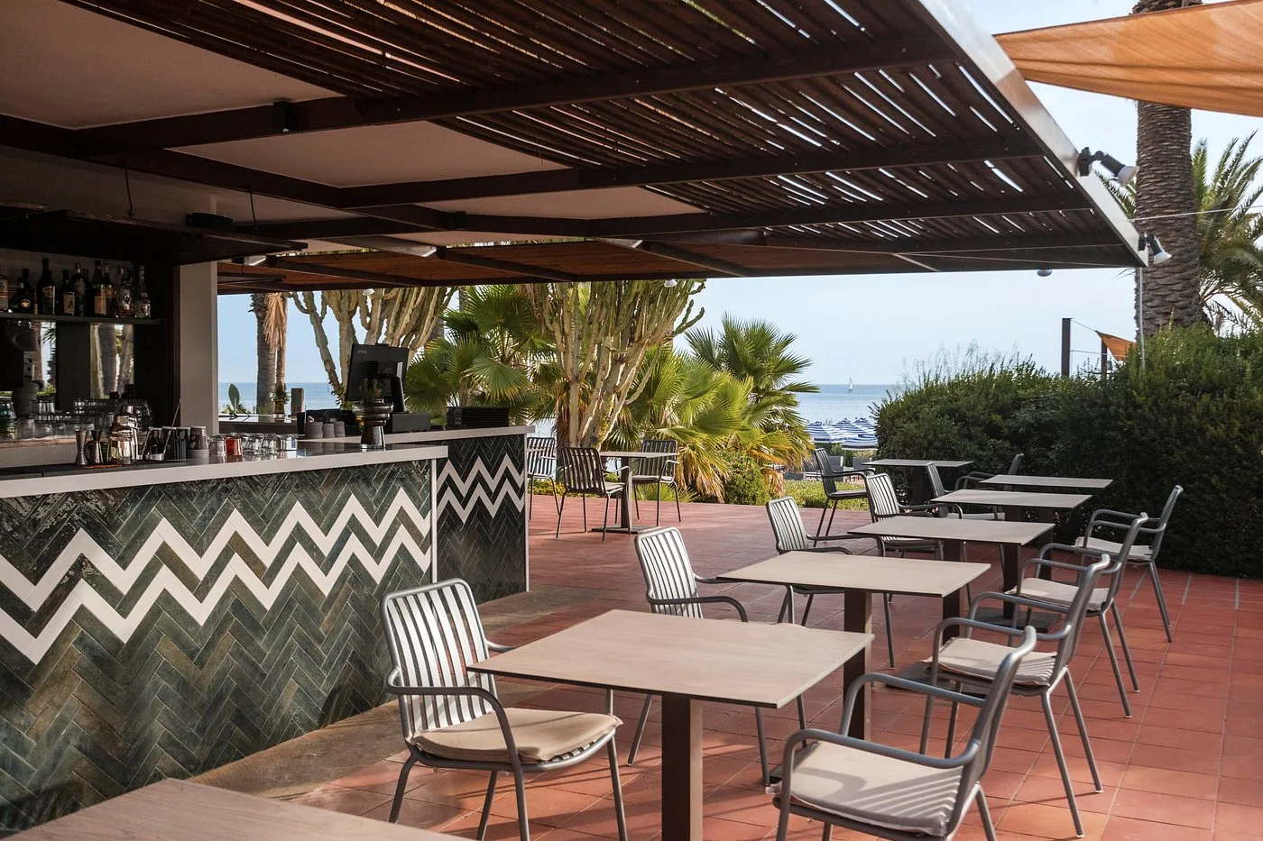 Bar esterno con pergolato in legno e tavoli vista mare