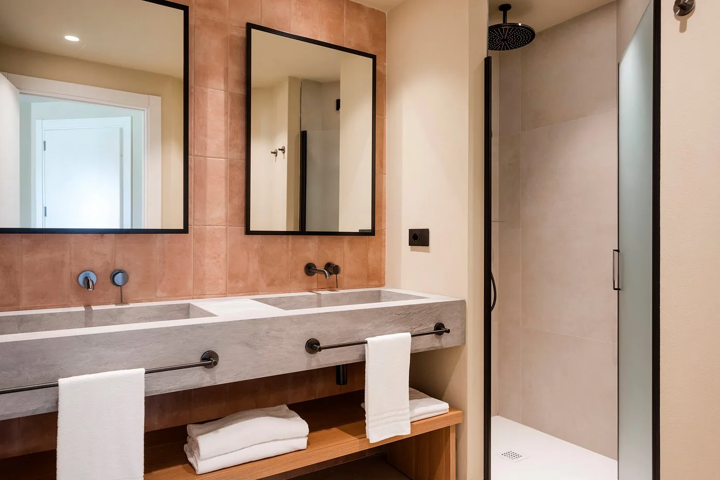 Bagno moderno con doppio lavabo in pietra e doccia a pioggia