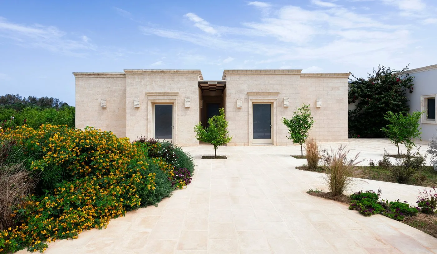 Ingressi delle camere in pietra chiara con giardino fiorito e vialetto