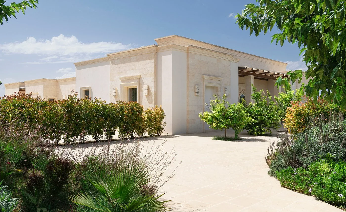 Esterno della masseria con giardino mediterraneo e vialetto in pietra