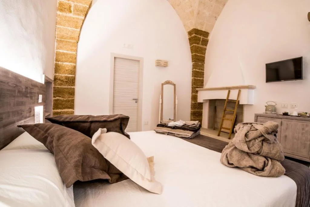 Camera con soffitto a volta in pietra, camino antico e arredi rustici