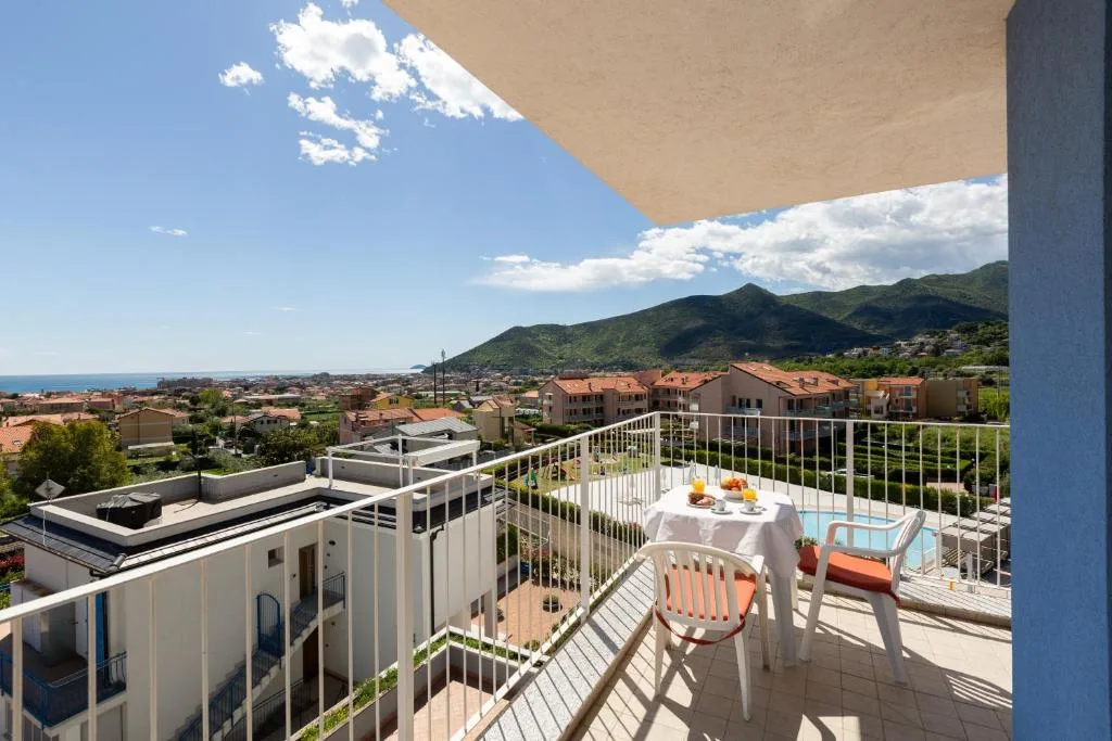 Balcone con tavolino da colazione e vista panoramica su mare, paese e montagne