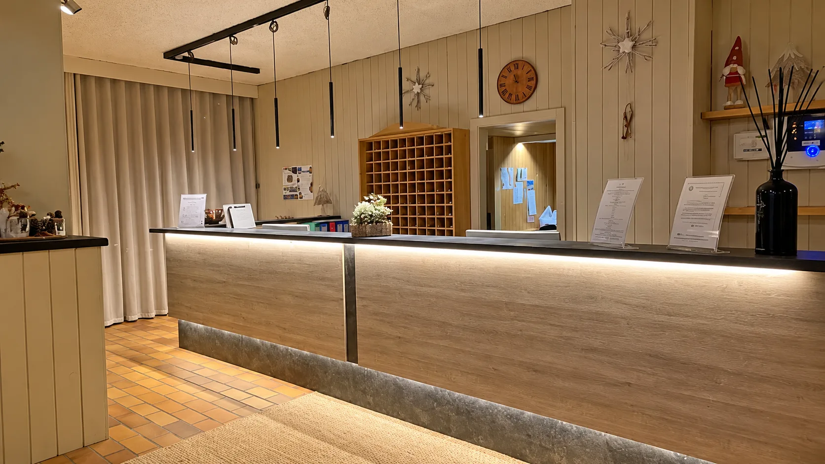 Reception dell'hotel con bancone in legno illuminato e decorazioni invernali