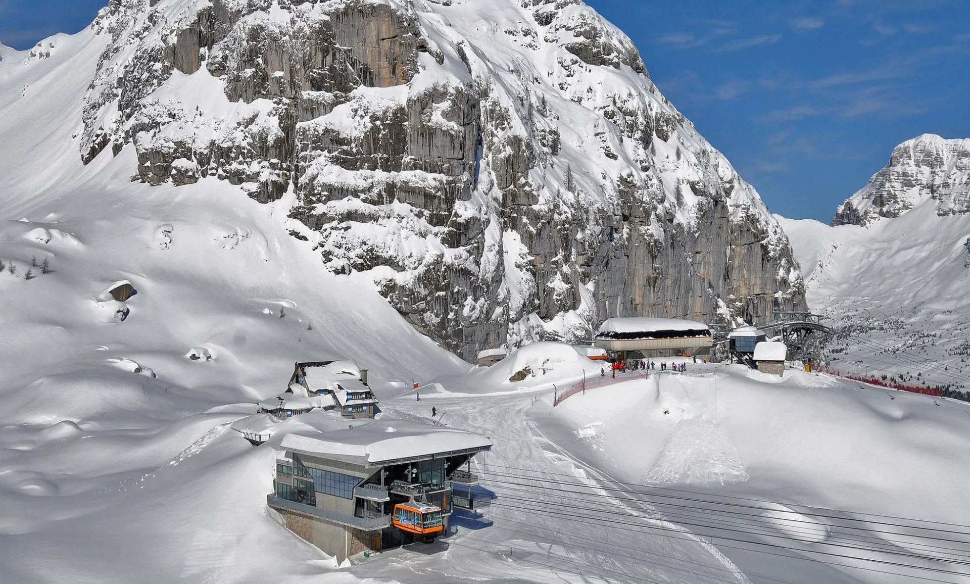 Impianti di risalita e stazione sciistica tra le pareti rocciose innevate