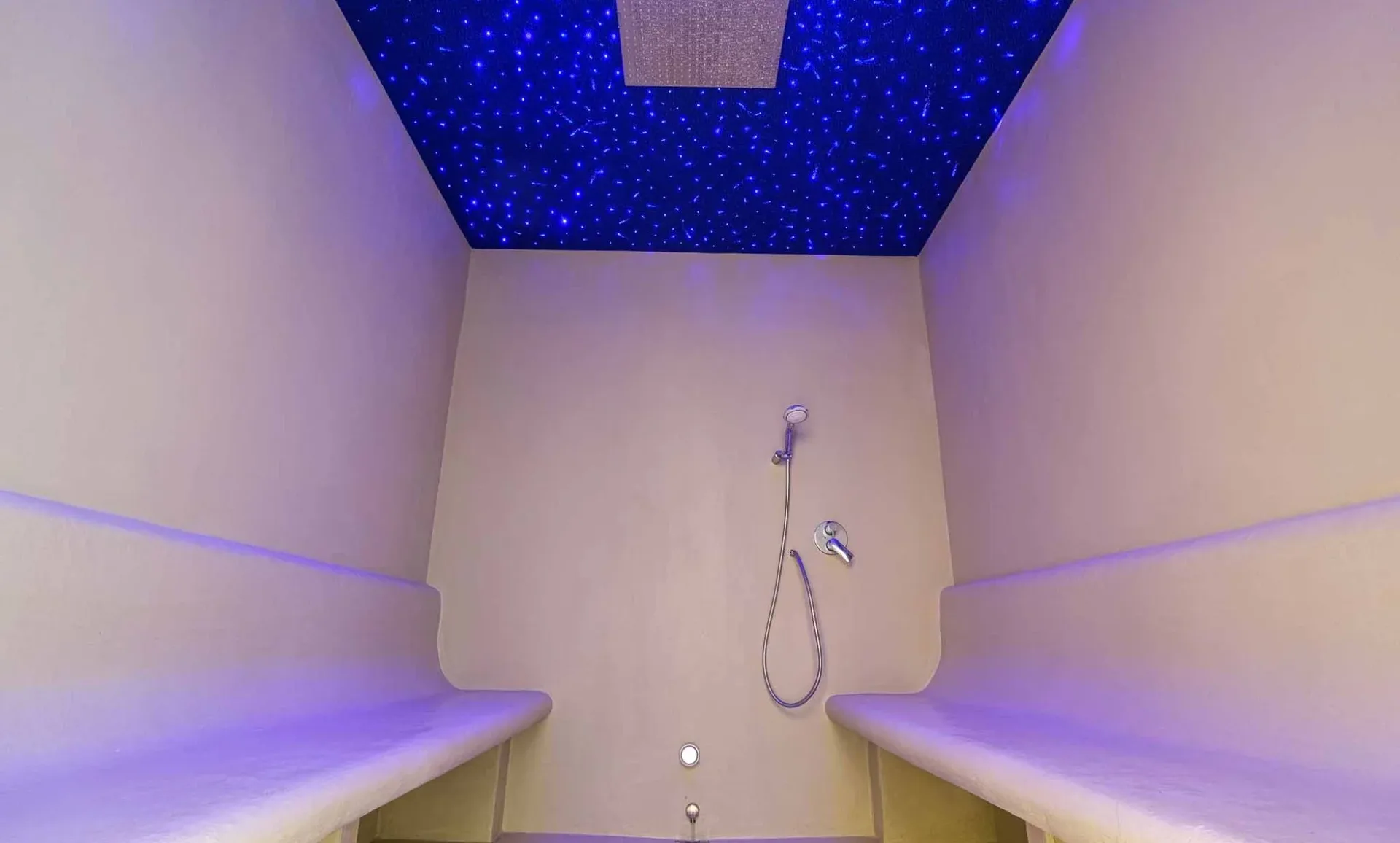 Bagno turco con soffitto stellato illuminato di blu e doccia