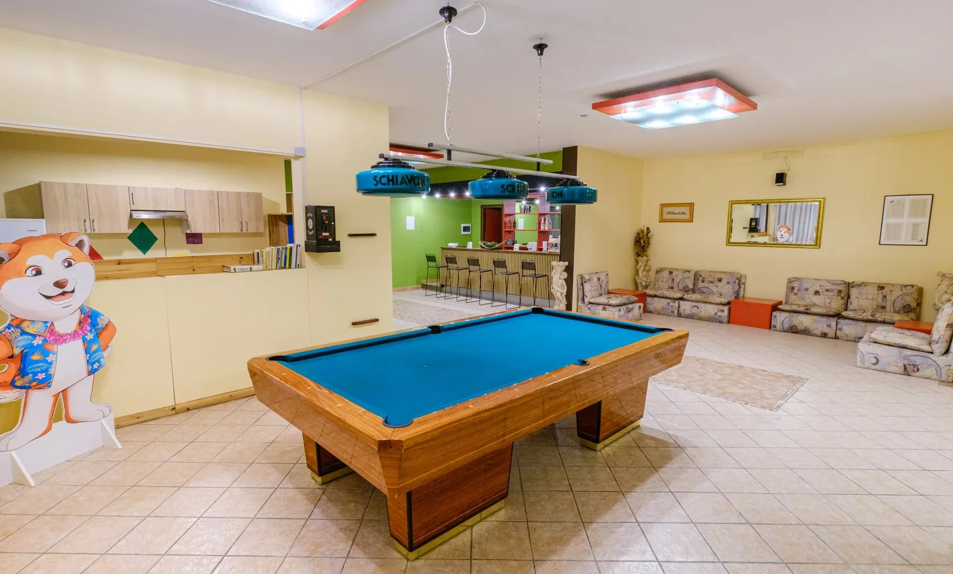 Sala giochi con tavolo da biliardo e area relax con divani