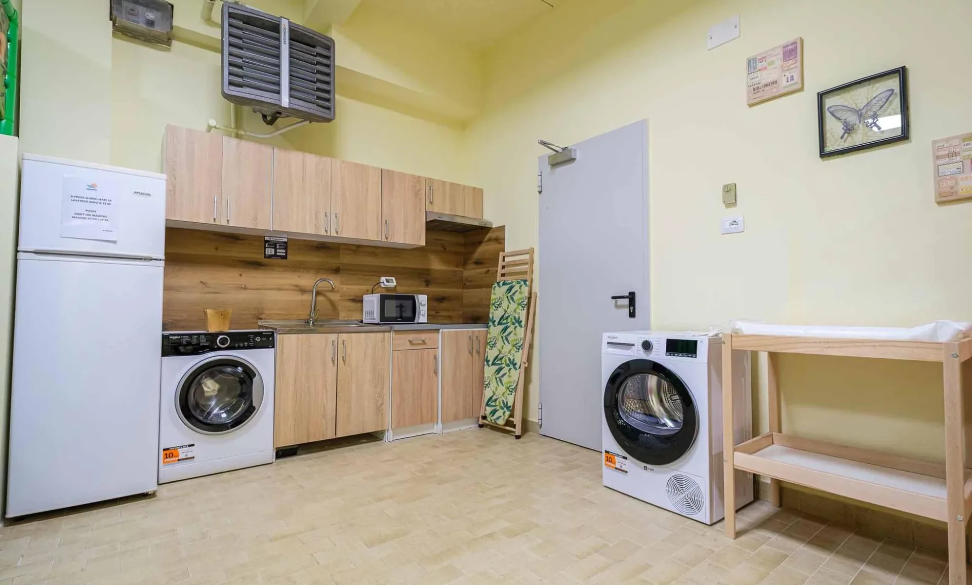 Zona lavanderia con lavatrice, asciugatrice e angolo cucina