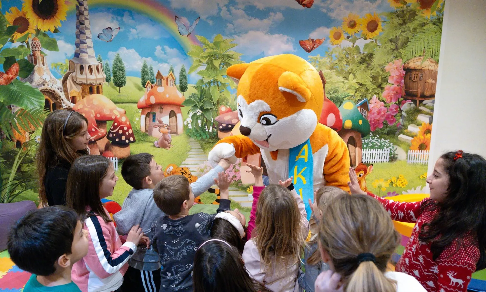 Bambini che giocano con la mascotte dell'animazione nella sala giochi