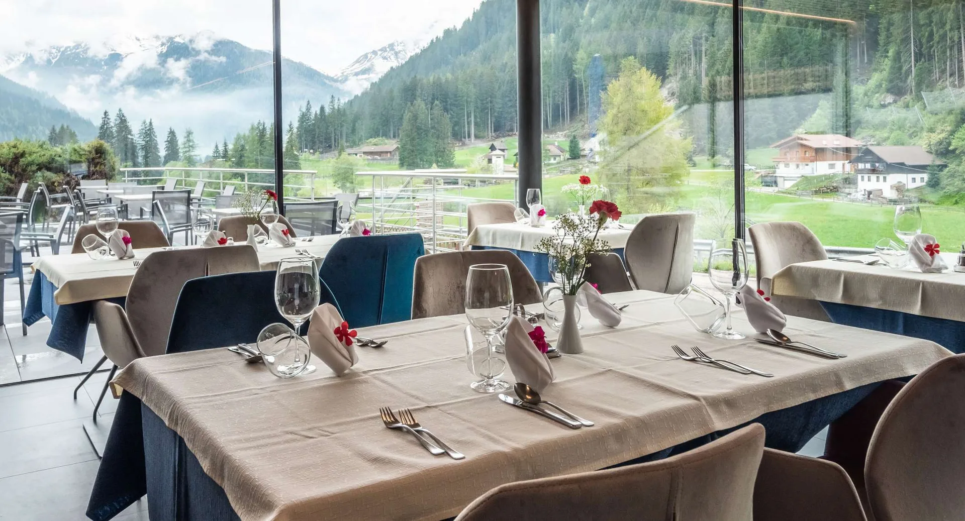 Sala ristorante con grandi vetrate e vista panoramica sulle montagne innevate
