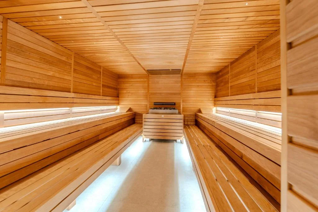 Interno di sauna finlandese in legno con panche illuminate