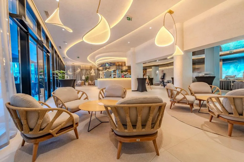 Hall moderna con poltrone imbottite, tavolini e lampade a sospensione di design