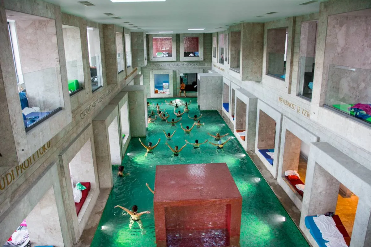 Lezione di acquagym in piscina interna con architettura in pietra