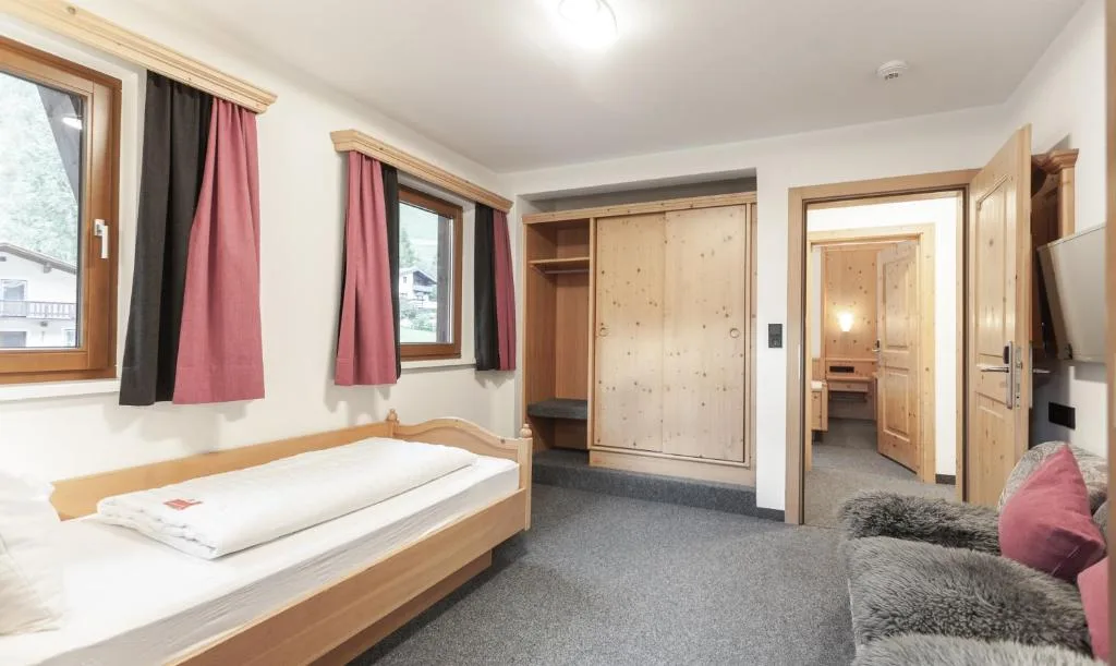 Camera con letto singolo, armadio in legno di pino e accesso al bagno