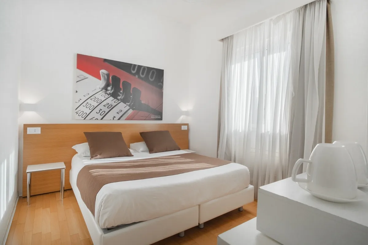 Camera con letto matrimoniale, testiera in legno e quadro decorativo