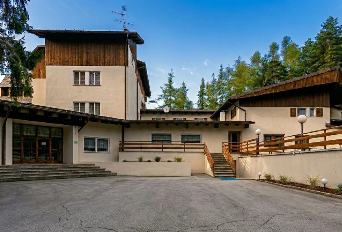 Cortile e ingresso dell'hotel con scalinate e dettagli in legno in stile alpino