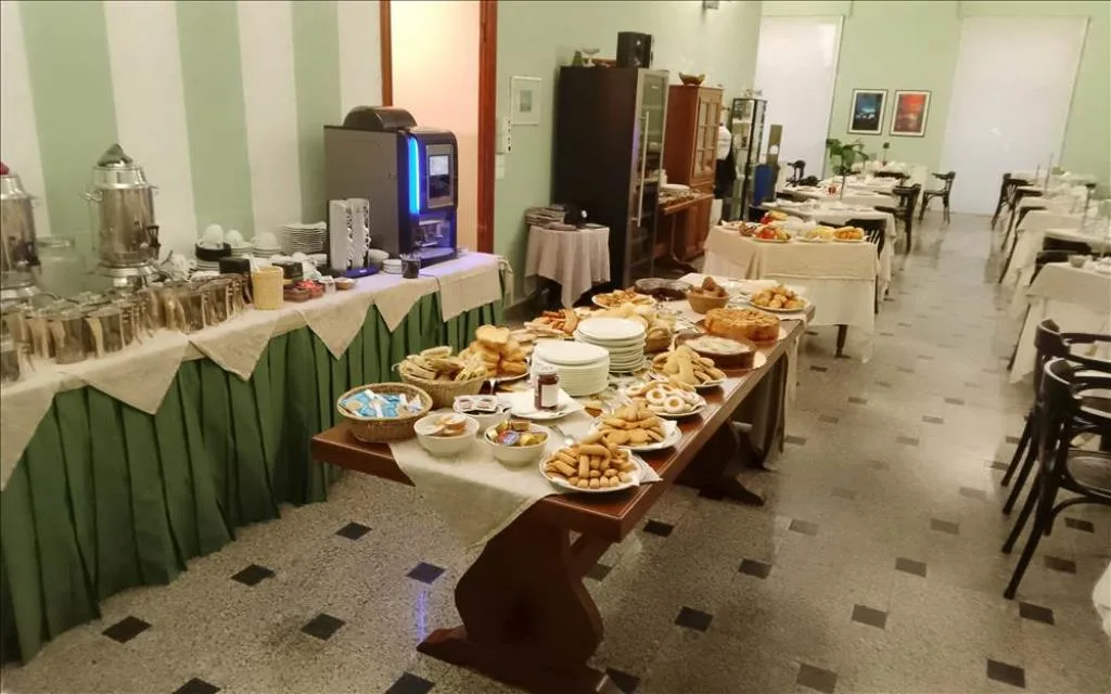 Buffet della colazione con dolci, pane e macchina del caffè nella sala