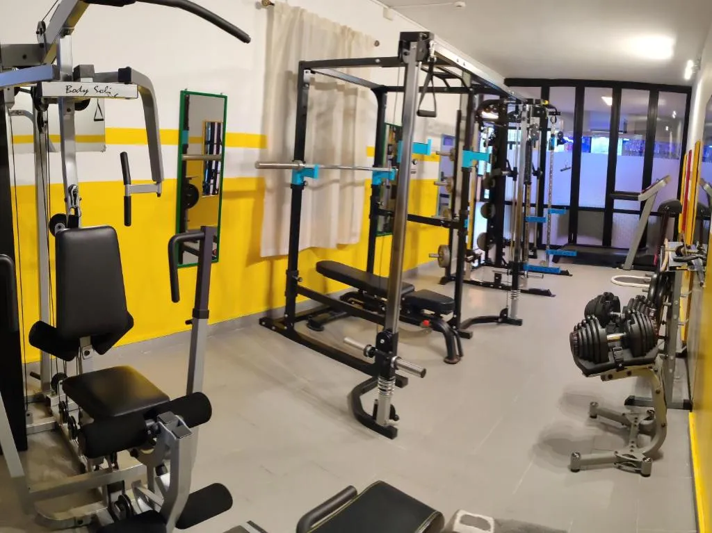 Sala fitness dell'hotel con attrezzi per pesi e pareti gialle