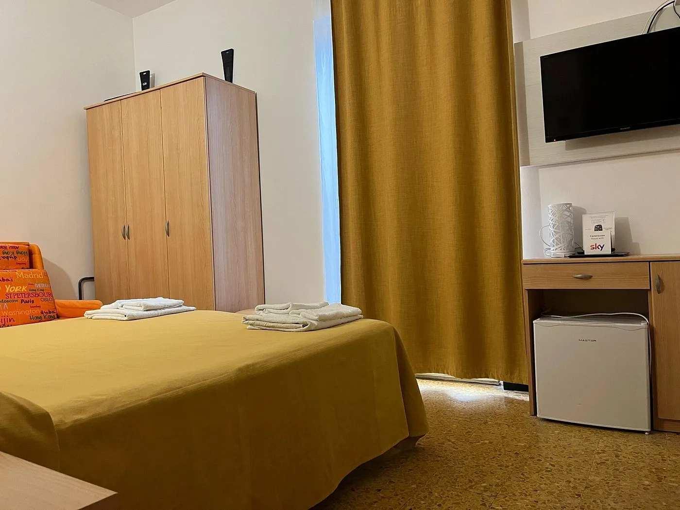 Camera con letto matrimoniale, armadio in legno, TV a parete e scrivania