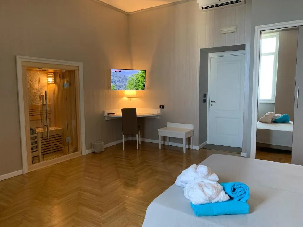 Camera spaziosa con sauna privata in legno, scrivania e pavimento in parquet