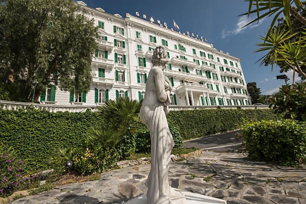 Facciata del Grand Hotel des Anglais con statua classica e giardino in primo piano