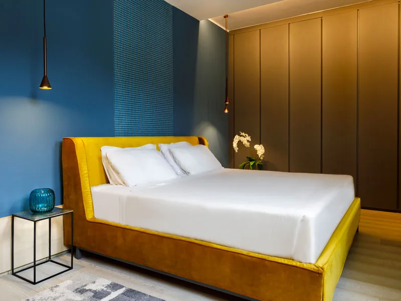 Camera di design con letto giallo e parete blu
