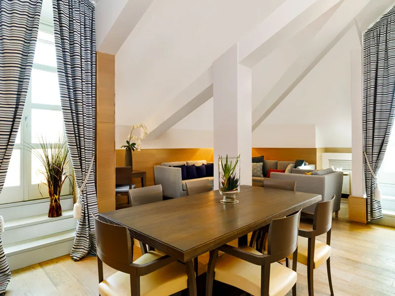 Sala da pranzo della suite mansardata con tavolo e divani