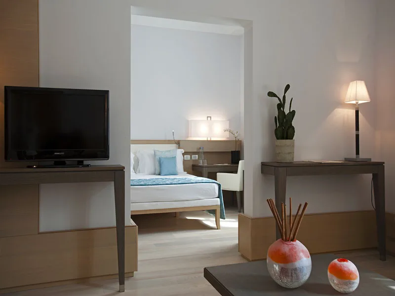 Camera elegante con zona living, televisore e dettagli arancioni