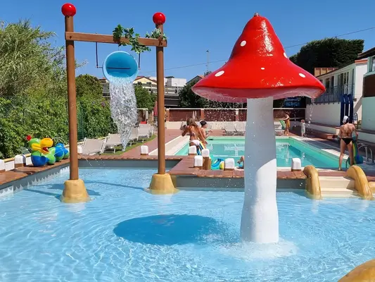 Piscina per bambini con scivolo a forma di fungo rosso e giochi d'acqua colorati