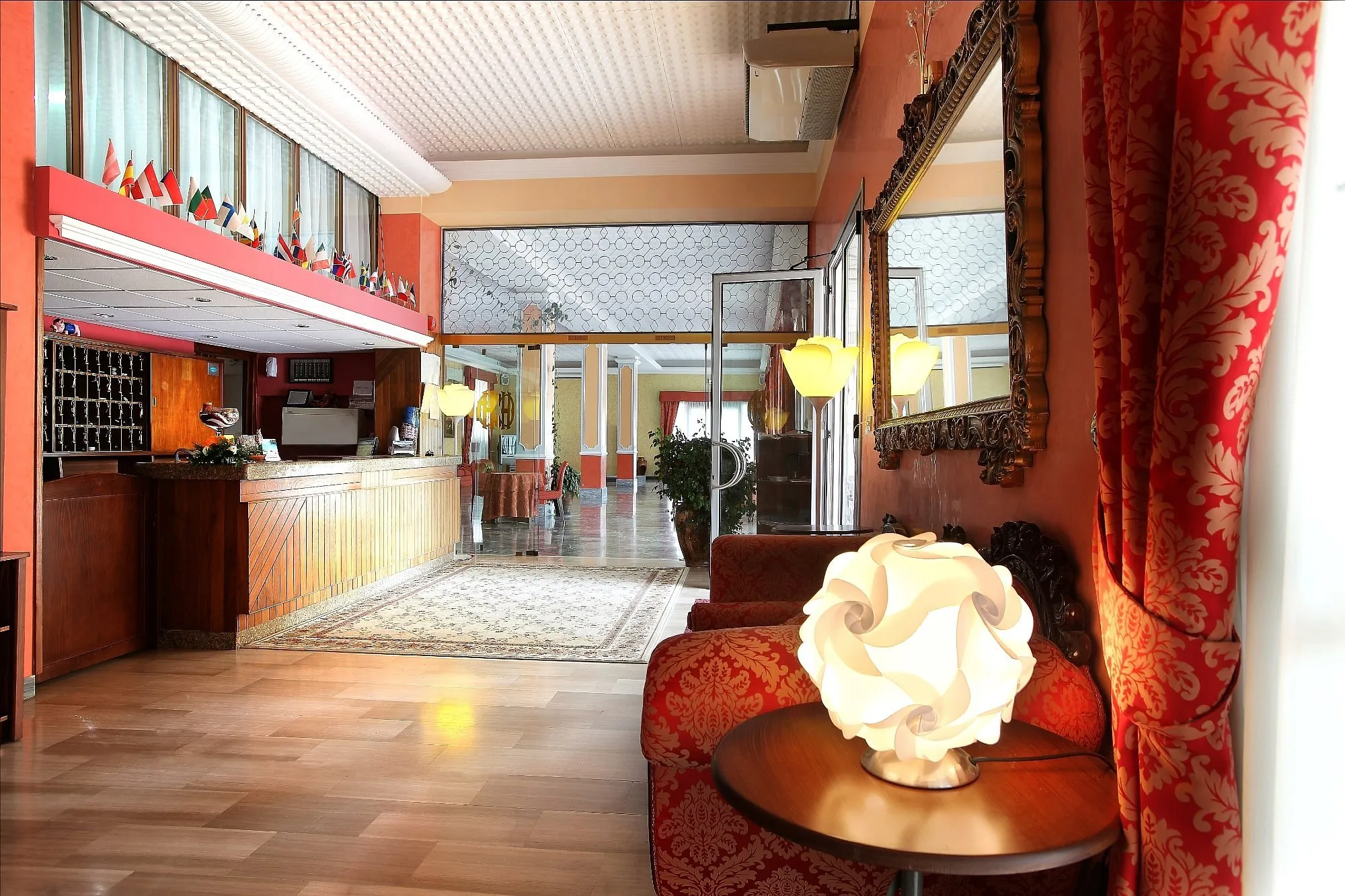 Reception dell'hotel con bancone in legno, bandiere e arredi classici