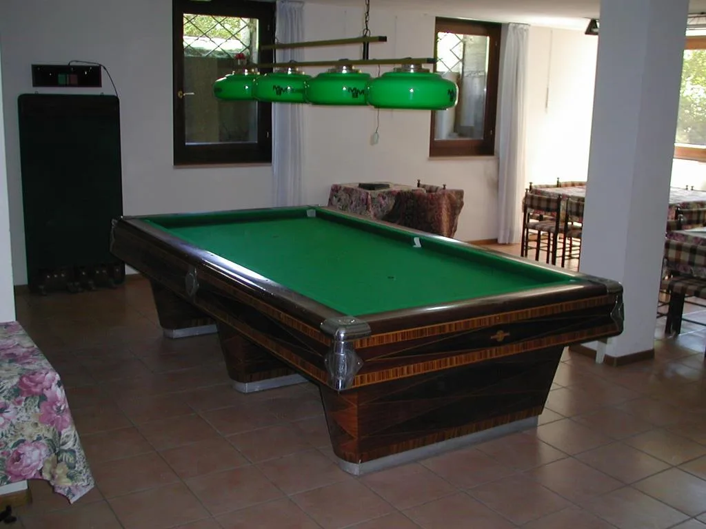 Sala giochi con tavolo da biliardo e lampada verde
