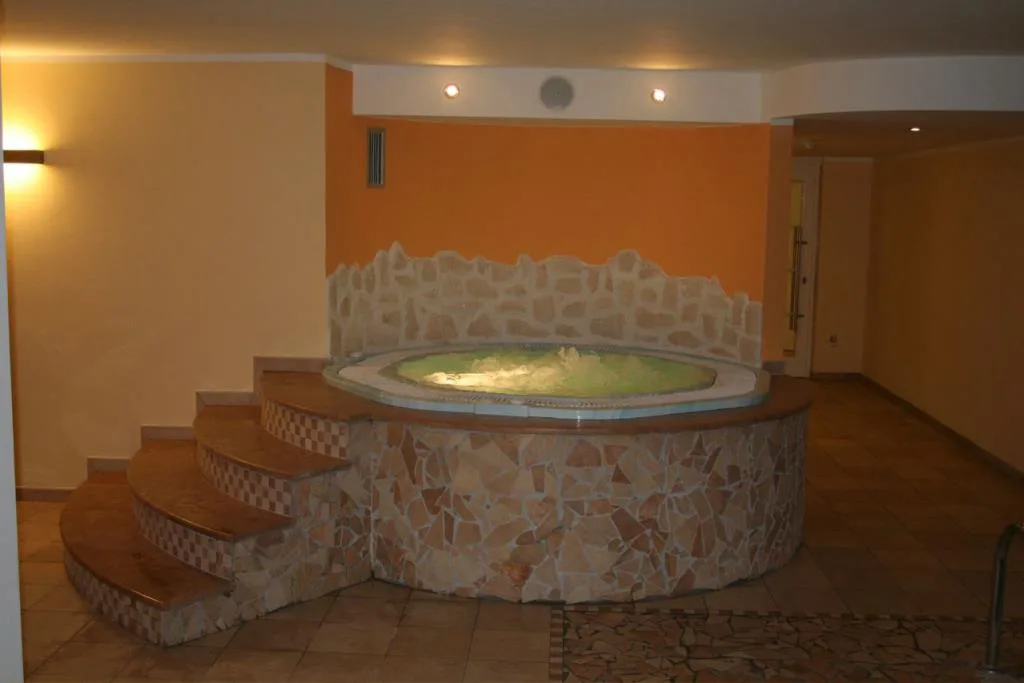 Vasca idromassaggio circolare con rivestimento in pietra nella zona spa