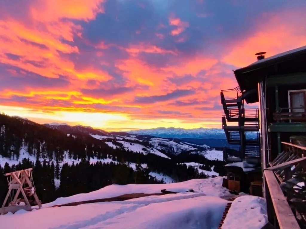 Cielo infuocato al tramonto sopra le montagne innevate vicino all'hotel