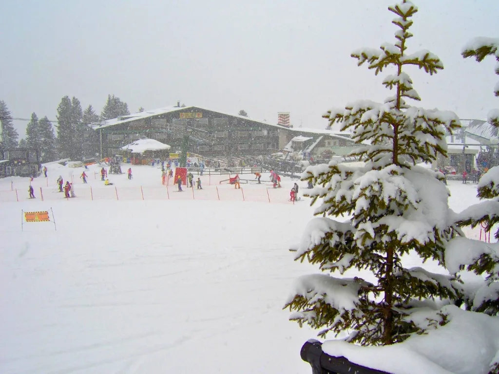 Hotel di montagna durante una nevicata con campo scuola per bambini