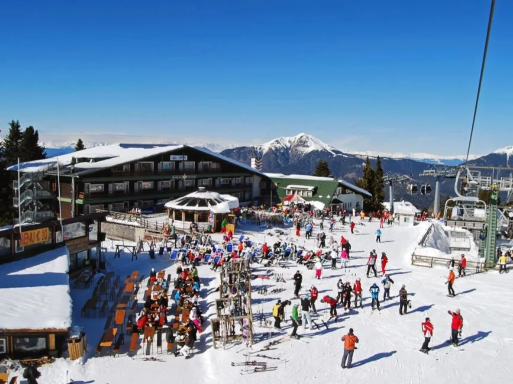 Terrazza affollata di sciatori davanti all'hotel in una giornata di sole