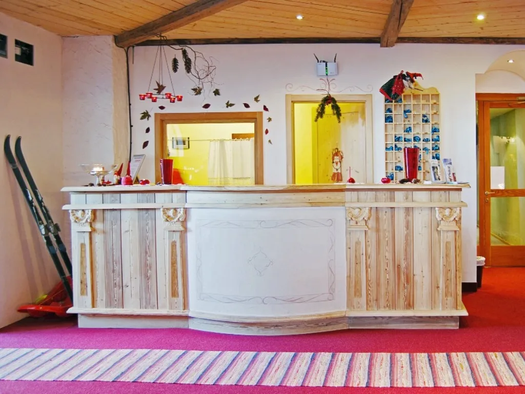 Reception dell'hotel con bancone in legno chiaro e decorazioni