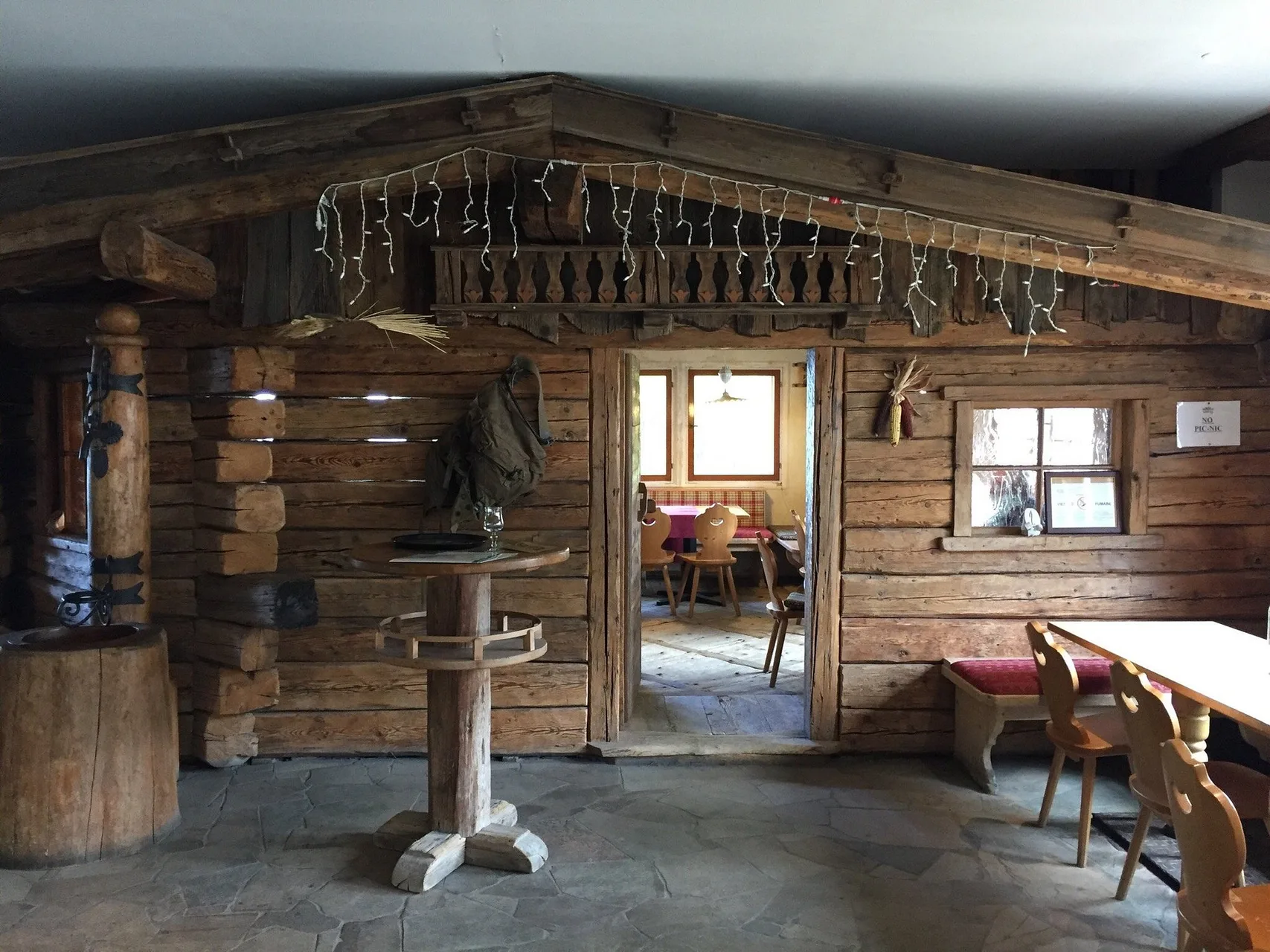Interno rustico in legno stile baita con arredi tradizionali alpini
