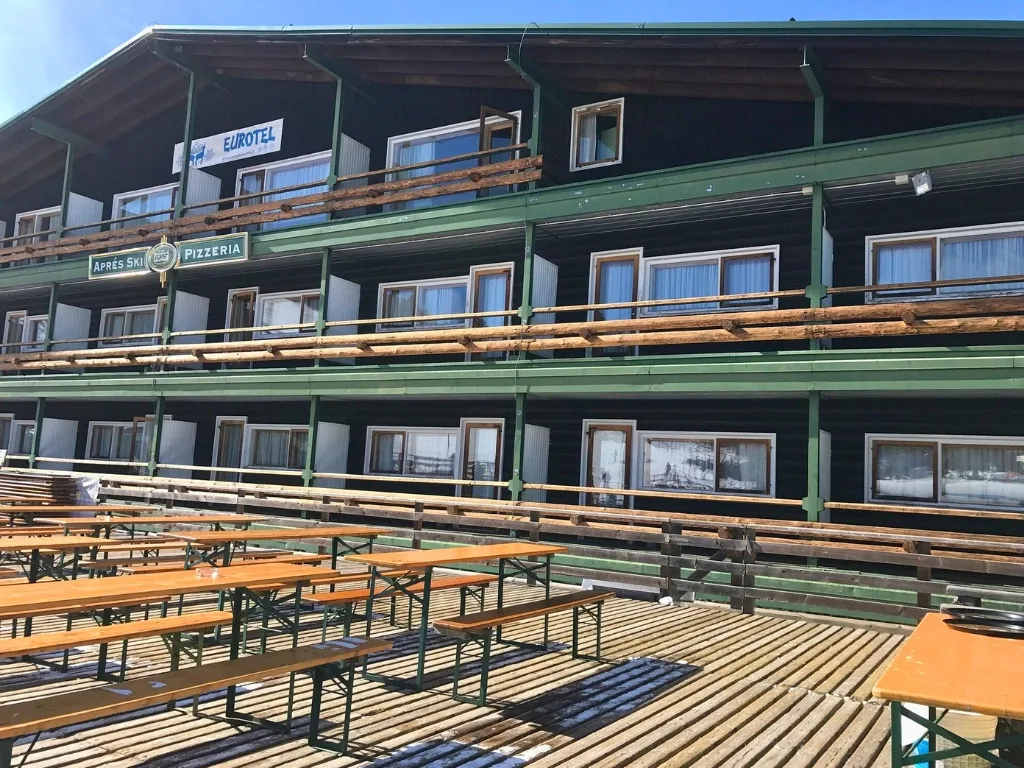 Facciata verde dell'Eurotel con balconi in legno e panche sulla terrazza