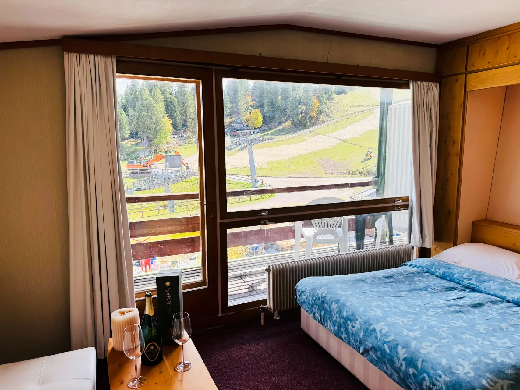 Camera con letto matrimoniale e ampia finestra affacciata sulle piste