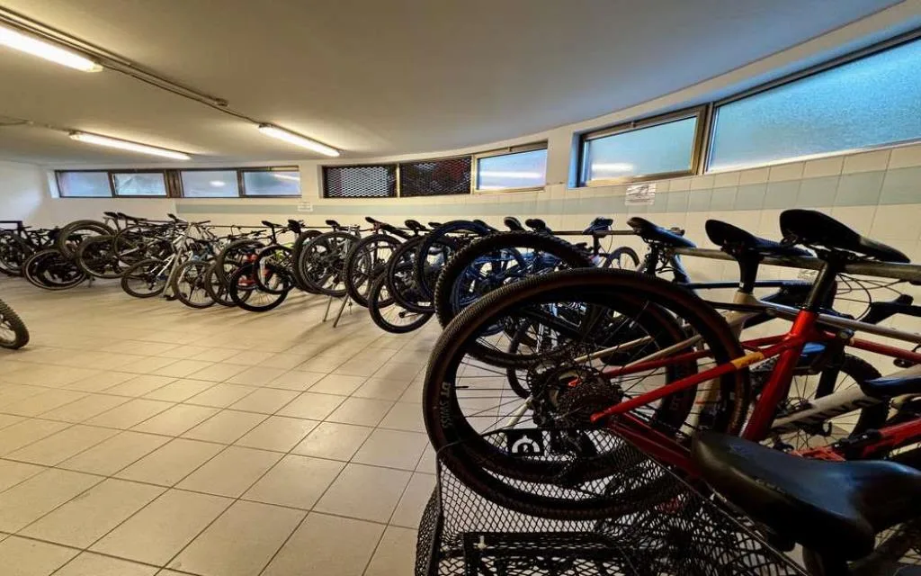 Deposito biciclette dell'hotel con numerose bici in rastrelliera