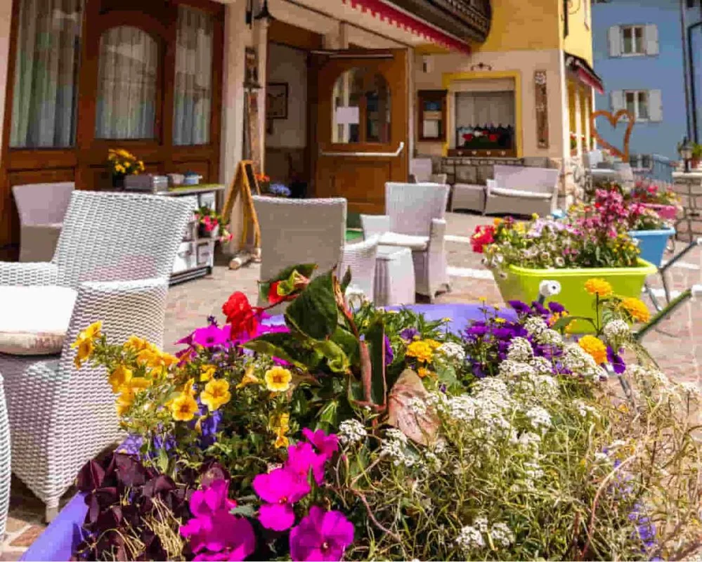 Terrazza esterna con poltrone in vimini e vivaci fioriere colorate
