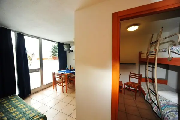 Interno dell'appartamento con zona pranzo e camera con letto a castello