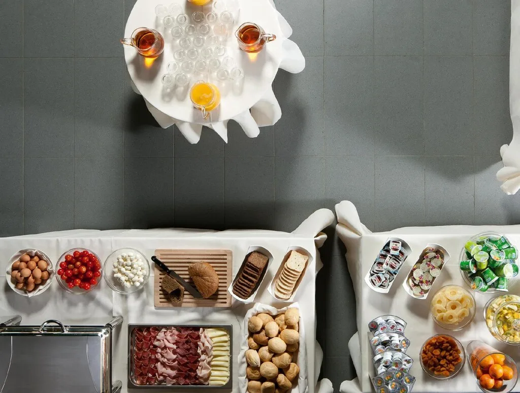 Vista dall'alto del buffet colazione con uova, salumi, pane e succhi