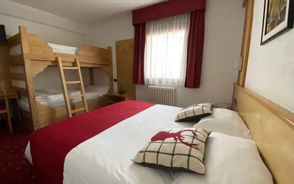 Camera familiare con letto matrimoniale e letto a castello in legno, cuscini decorativi con cervo
