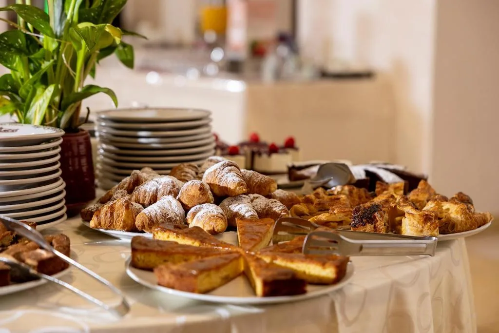 Buffet di dolci e cornetti con piatti impilati per la colazione