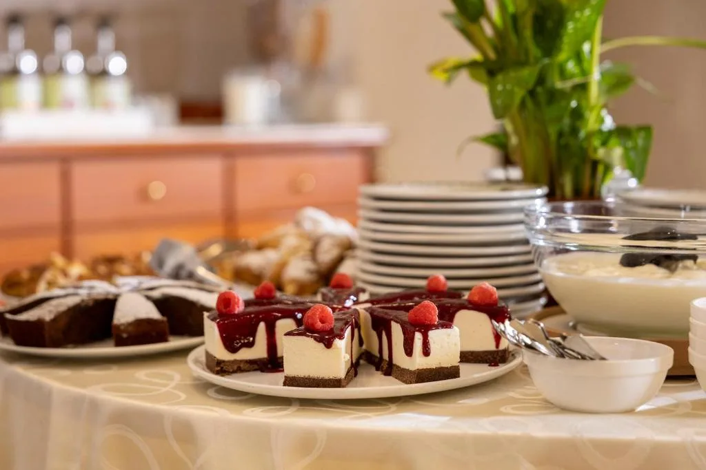 Dettaglio di cheesecake ai frutti di bosco e torte su buffet